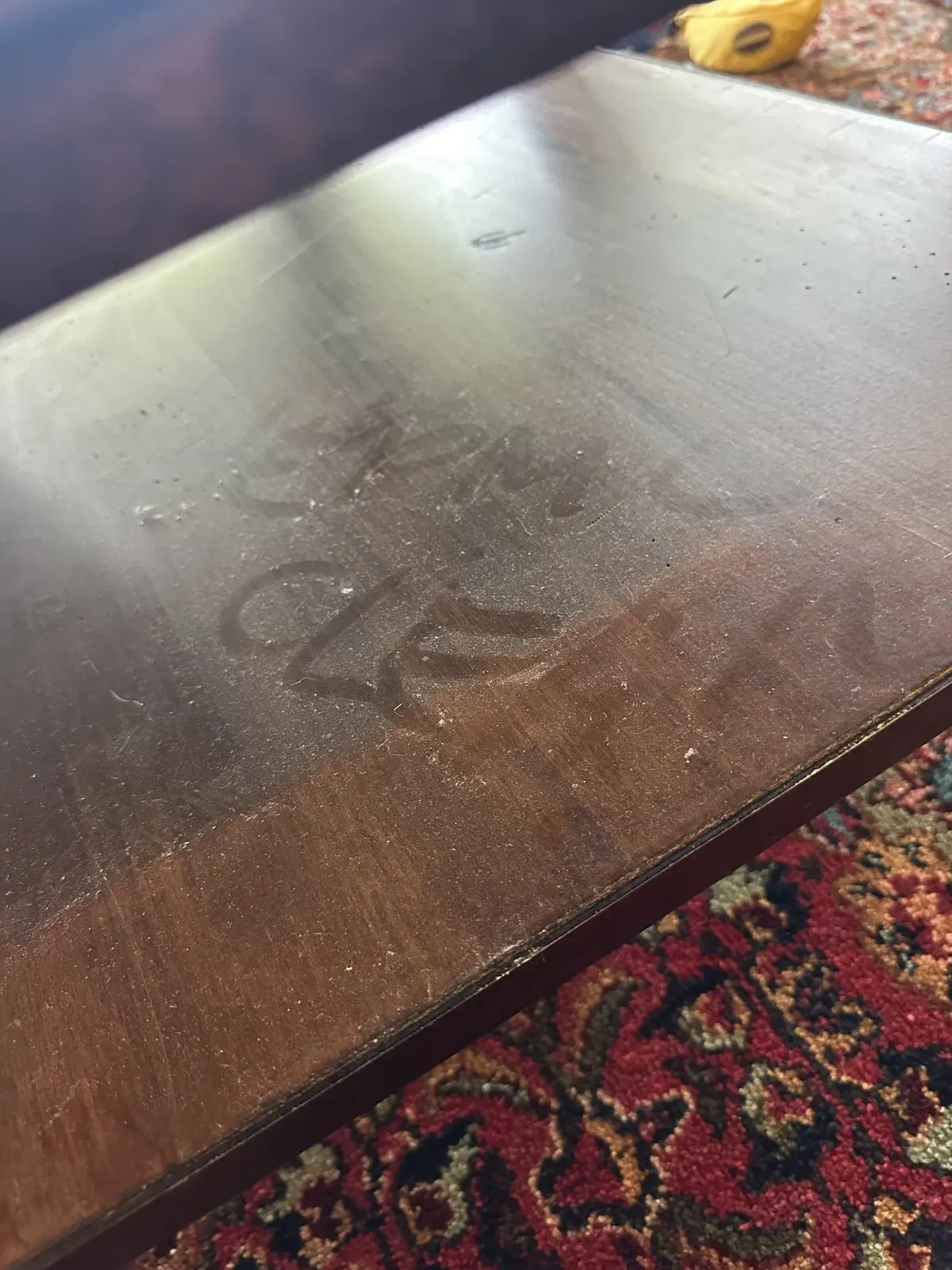 HelpMeClean written by hand in the dust on a table, before cleaning