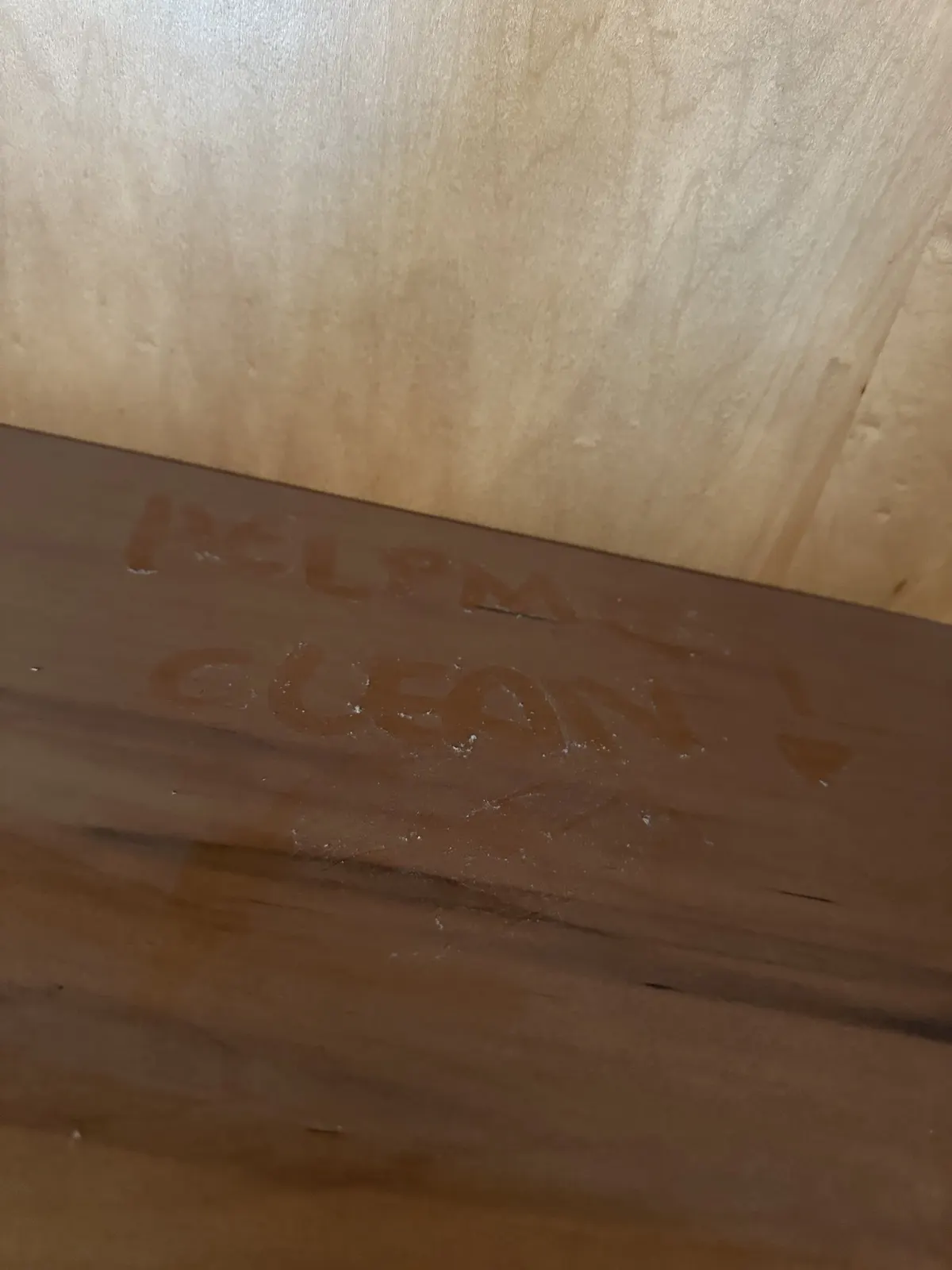HelpMeClean written by hand in the dust on a shelf, before cleaning